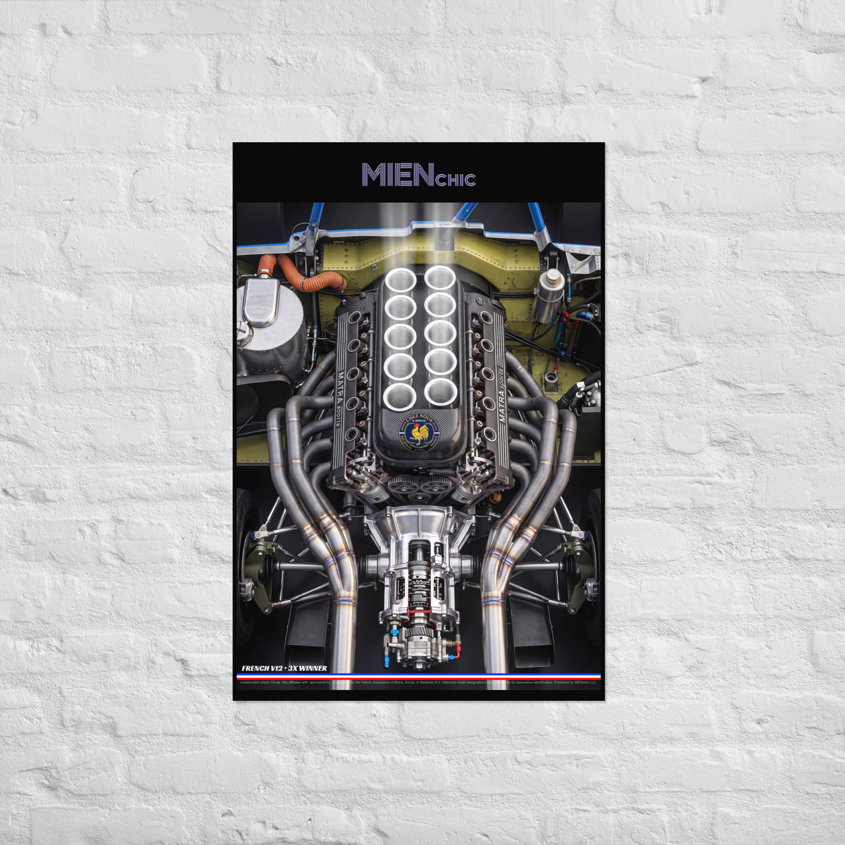 A vertical poster featuring a detailed photograph of a Ferrari engine, mounted on a white painted brick wall. The poster has a black header with the text 'MIENchic' and a small Ferrari logo at the bottom.