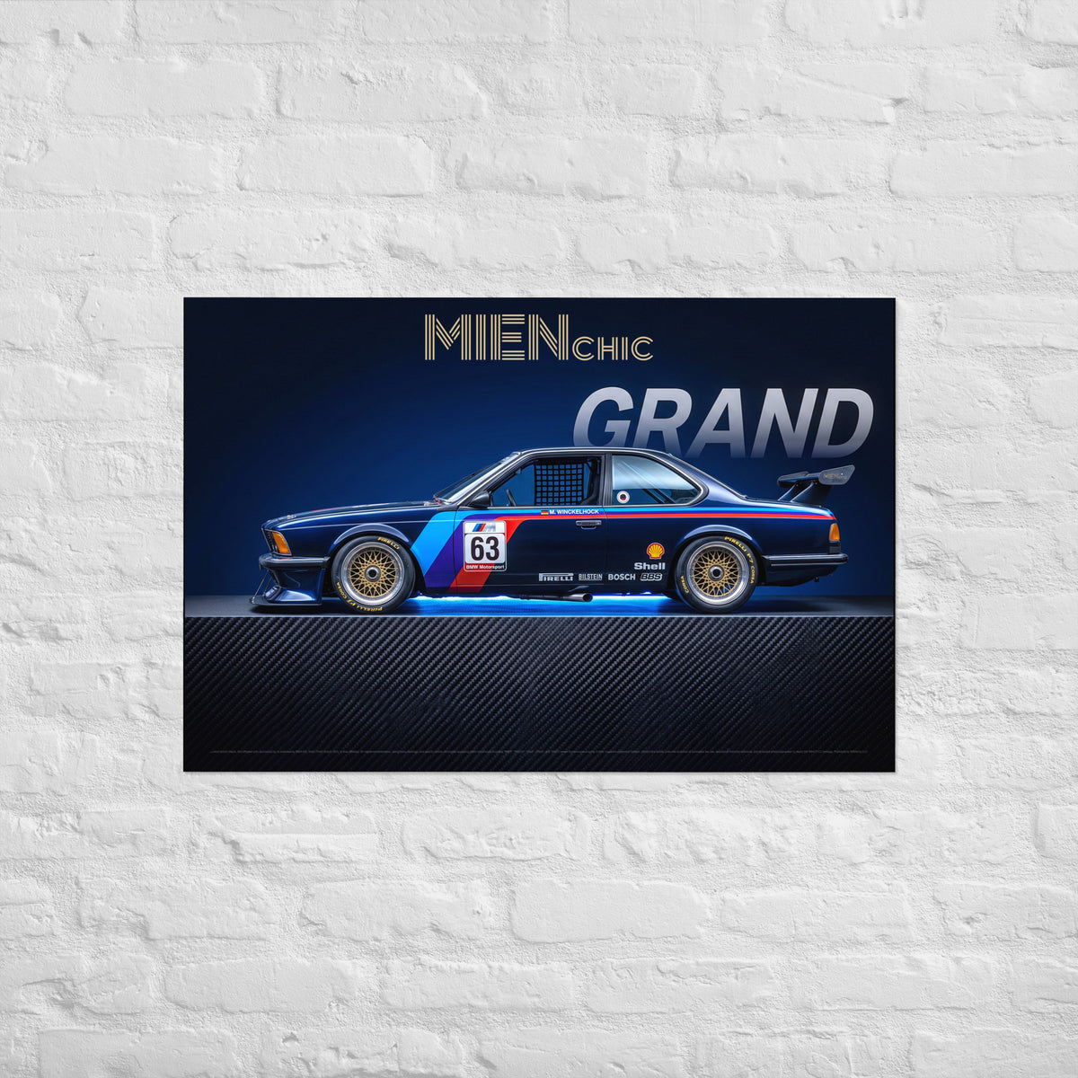 A rectangular wall art print showing a blue and red race car with the text 'MIENCHIC GRAND' above it, mounted against a white painted brick wall.